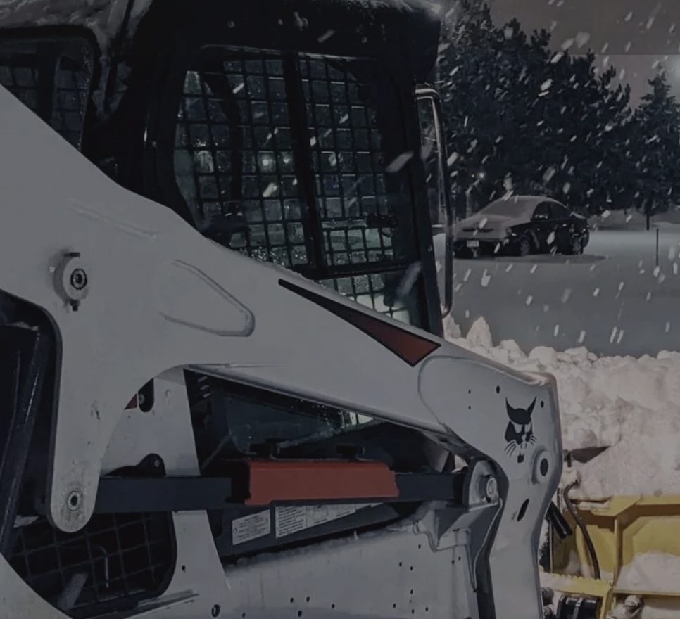 Bobcat compact track loader clearing snow on a Rochester NY property